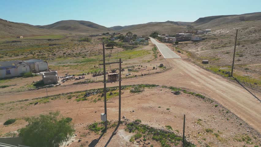 Pan around electricity transformer perched on elevated poles above the ground at entrance to town of Lekkersing, Richtersveld