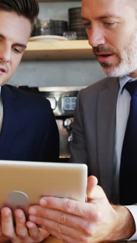 Two people watching their tablet at restaurant