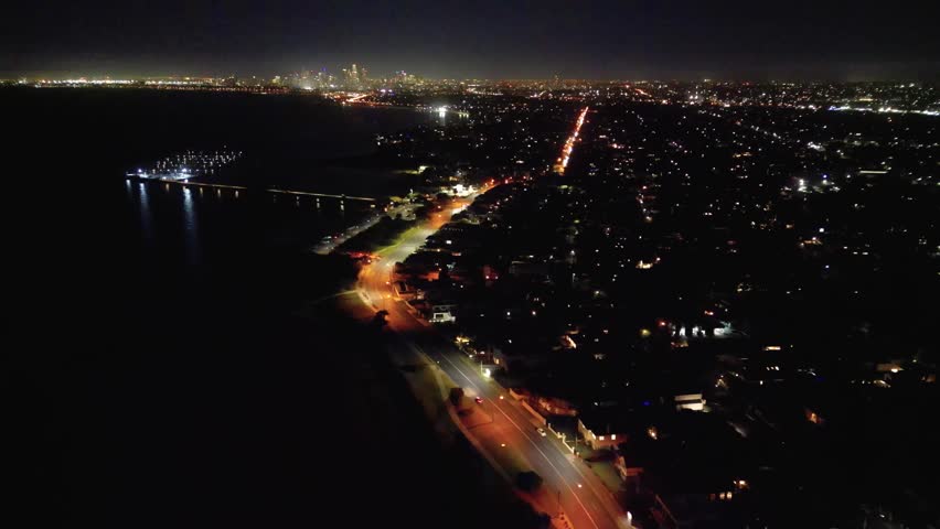 Aerial drone footage of the suburb of Brighton in Melbourne Australia at night.