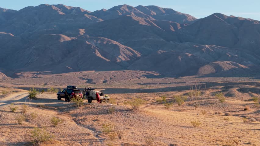 Experience aerial views of a teardrop camper and an SUV camping in Anza Borrego Desert State Park along Thimble Trail in California.