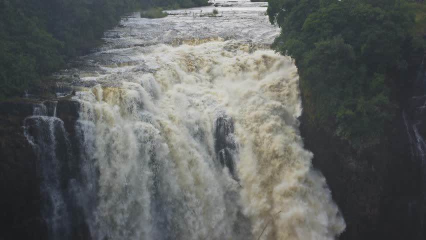 Rushing water of Victoria Falls plunging into Zambezi River gorge, powerful cascade on Zimbabwe and Zambia border showing immense natural power and untamed wilderness