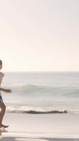 Father and son playing with a crocodile buoy on the beach