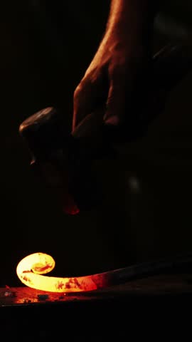 Mid-section of blacksmith working on a iron rod in workshop 4k