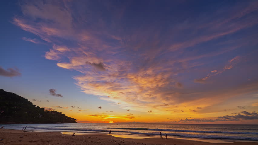 A serene beach scene in timelapse, showcasing the transition from golden hour to twilight with dynamic clouds and soft waves.