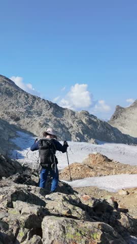 Adventurous Hiker Descending Rocky Terrain Towards a Glacier in British Columbia, Canada
