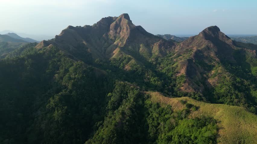 Top view shot of Mt. Batulao presents a picturesque mountain landscape with layered hills, open skies, and tranquil hiking routes in Balayan, Batangas, Philippines.