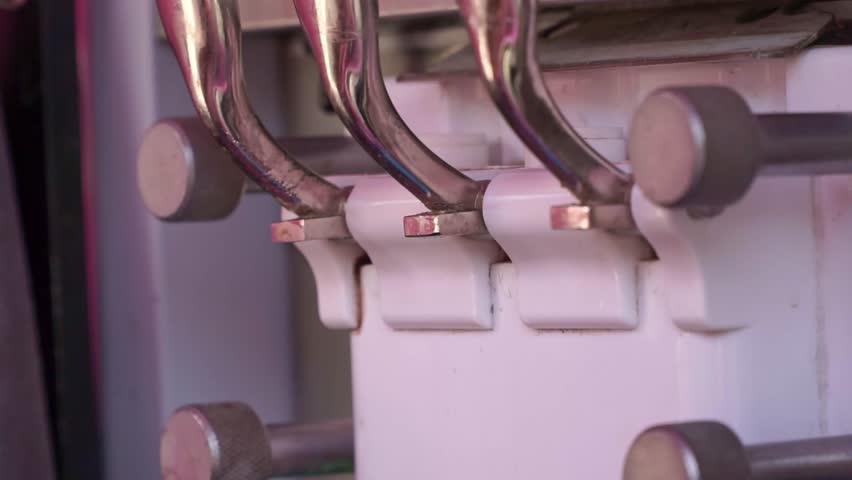 Soft serve ice cream flowing from machine into plastic cup, close-up detail, dessert making process, frozen treat, food industry equipment.