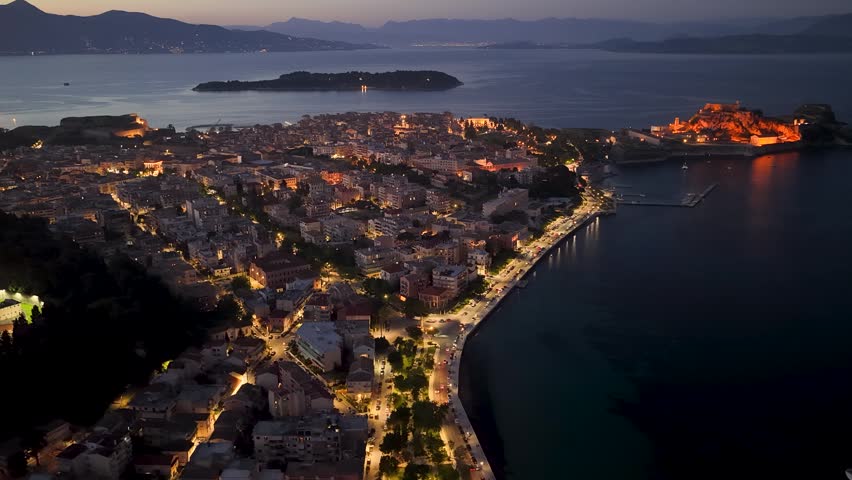 Majestic aerial night view of Corfu Town and Old Fortress. Illuminated historical architecture, Old Town streets, and Ionian sea coastline at dusk, Kerkyra, Greece
