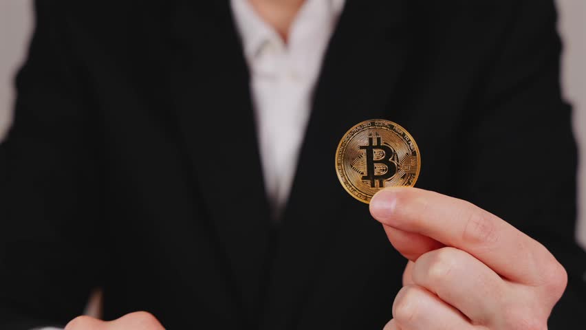 A person holding a dollar bill and a bitcoin in their hands, symbolizing digital and paper currencies.