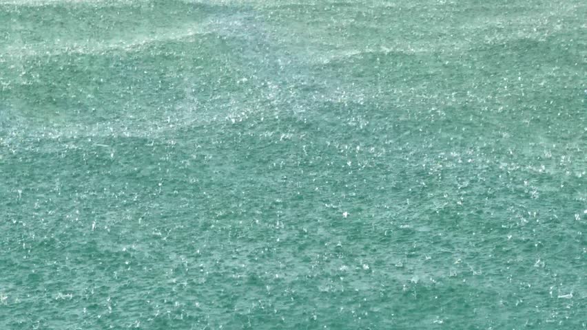A rainstorm over the ocean with water droplets.