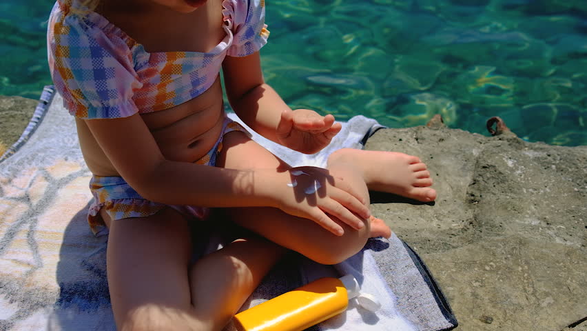 The child has sunscreen on her hands. Selective focus.