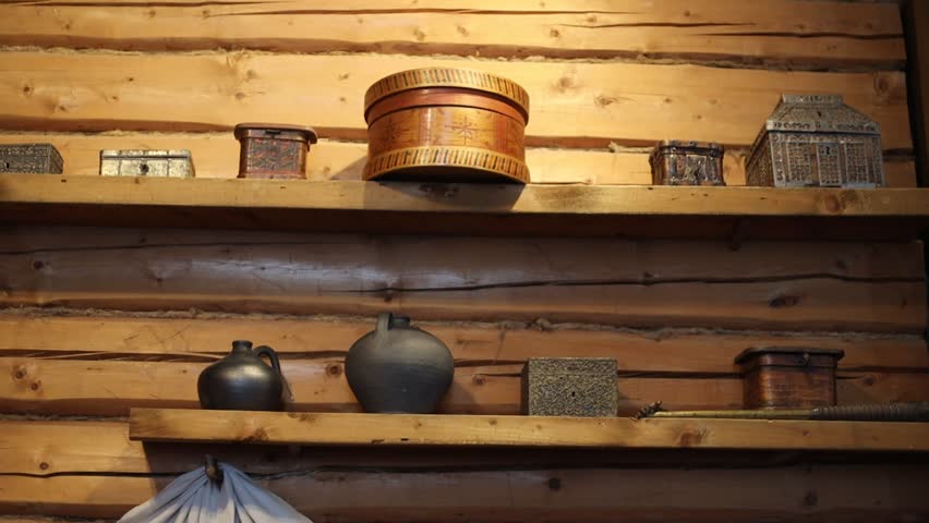 A wooden shelf filled with ceramic pots and vases.