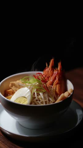 Curry Laksa which is a popular traditional spicy noodle soup from the culture in Asia. noodle soup with shrimp, tofu and sprouts, selective focus, low key lighting