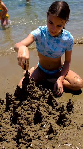 Children playing with sand on the beach. Selective focus.