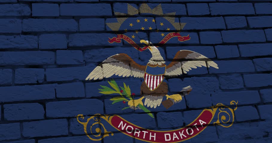 A panning video of a brick wall with the north dakota state flag of the United States of America