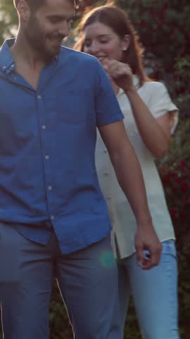 Handsome man giving piggy back to his girlfriend in the garden