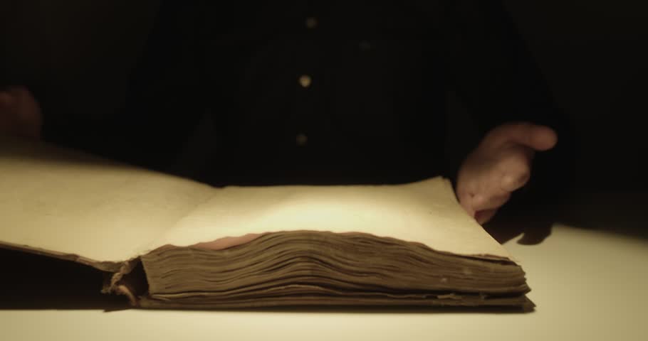 Hands of a prayer clasped over a vintage aged Holy Book. Religion and praying concept video.