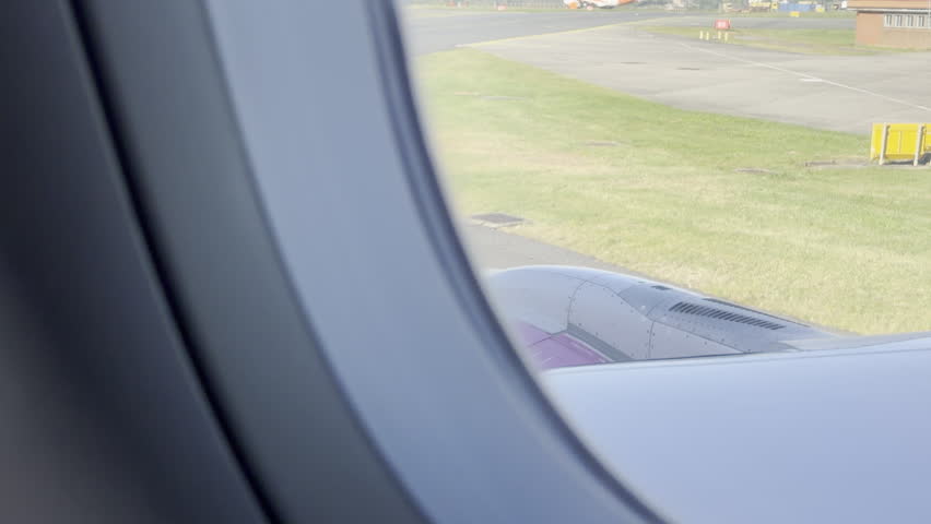 Airplane window view over purple wing panning