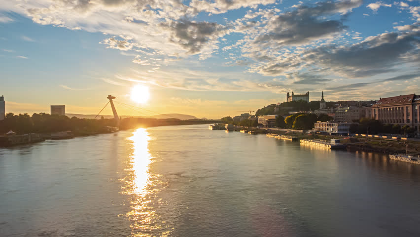 Bratislava old town and SNP bridge at sunset over of calm Danube river hyper lapse. Slovakia.