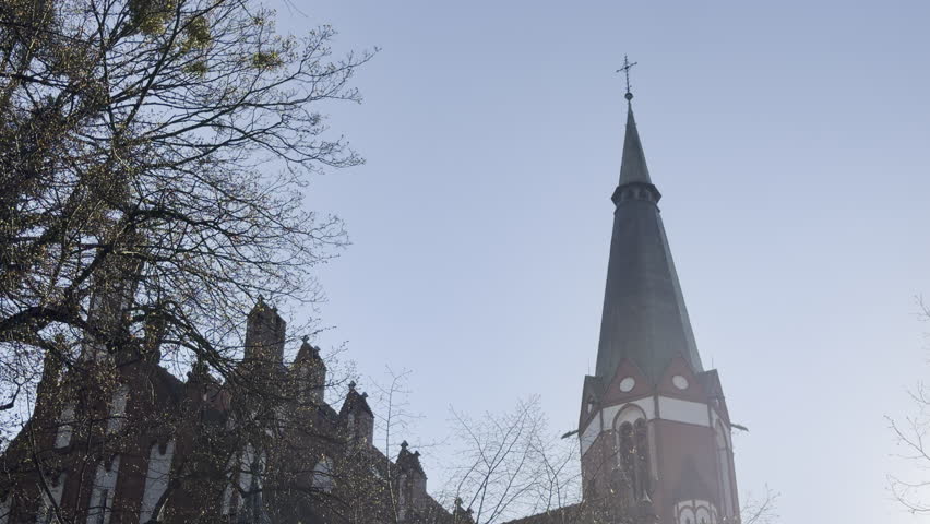 Old brick church with tall steeple panning