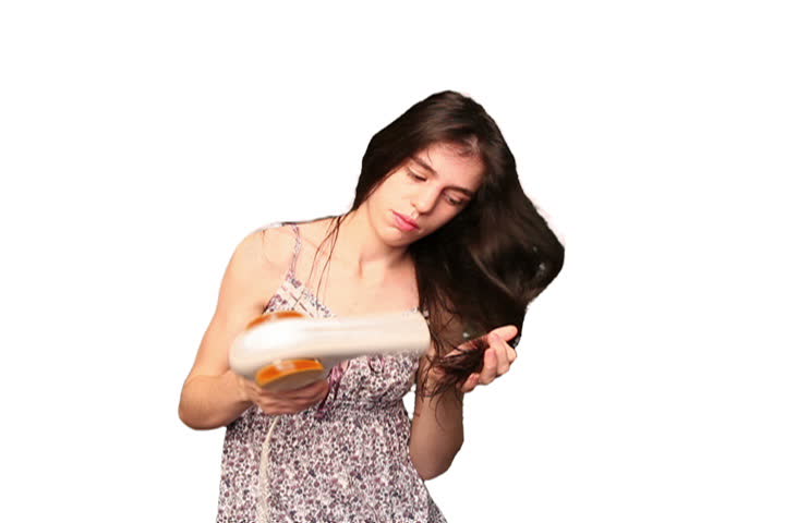 Attractive brunette young adult woman blow dries her hair. Alpha matte included.
