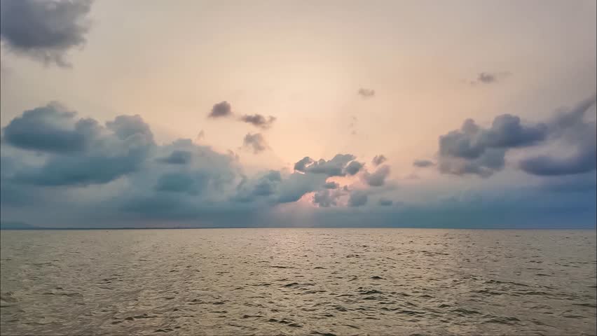 Serene Seascape Under Cloudy Skies: A tranquil ocean stretches endlessly towards the horizon, beneath a vast expanse of dramatic, cloud-filled skies, creating a sense of peace and contemplation.