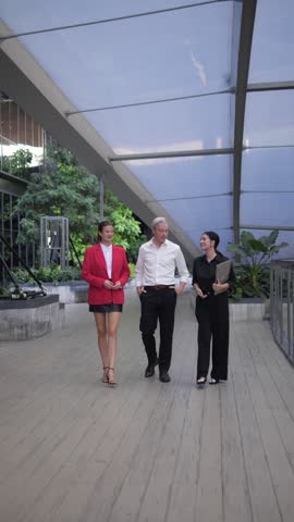 Dynamic Trio: Engaged in a Lively outdoor discussion, Three diverse professional walking the path of progress and innovation.