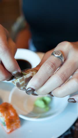 Close-up shot of hands extracting meat from a sea snail at a seafood buffet restaurant
