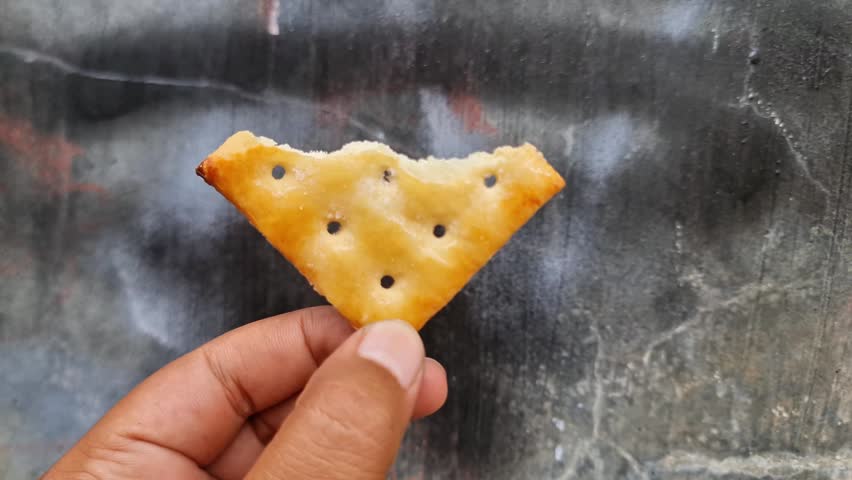 Crispy Golden Brown Sugar Crackers Held by Hand  Delicious Crunchy Sweet and Salty Snack
