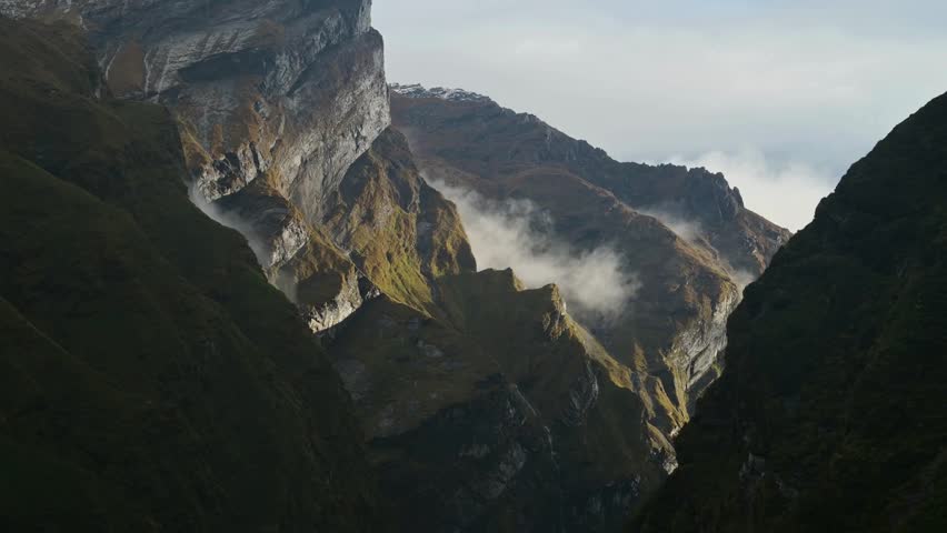 Breathtaking views of Himalayan mountains in Nepal revealing steep cliffs, lush valleys, and swirling mist under a vast sky, ideal for travel and nature enthusiasts.