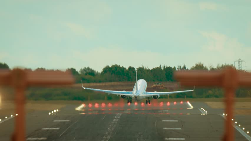 Aircraft taking off with visible heat trails from turbines over runway. Jet departing and climbing with shimmering exhaust distortion behind engines under clear sky. Airliner lifting off with strong