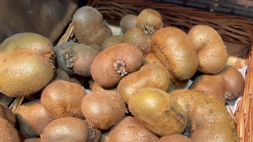 Female hand choosing fresh kiwi in supermarket. High quality 4k footage.