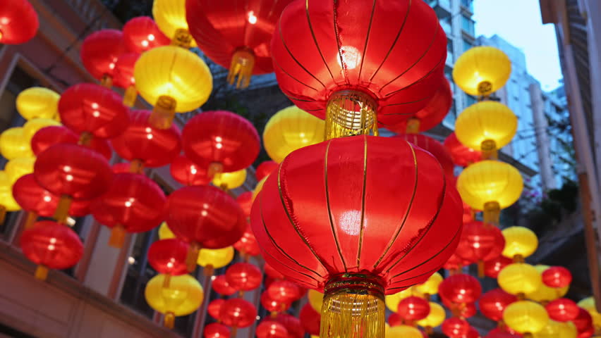 Close-up of vibrant red and yellow lanterns hanging above a Hong Kong street for Chinese New Year. Illustrates festive Lunar New Year decorations, cultural traditions, and holiday spirit in Asia.