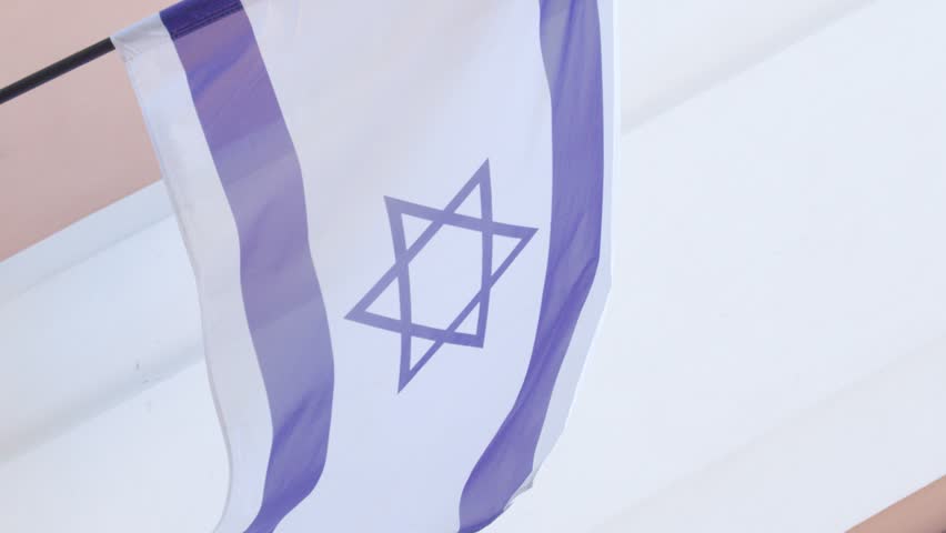 Israeli flag waves, star of David symbol.