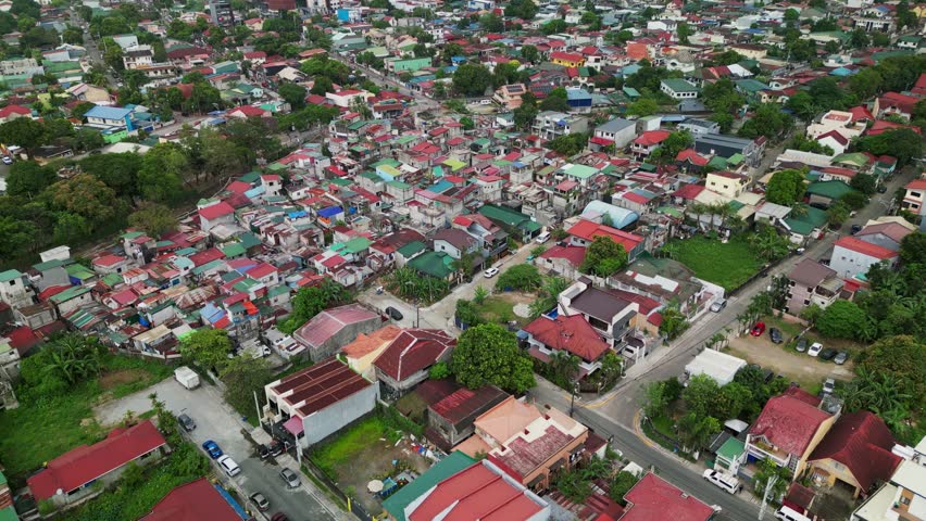 Aerial shot of a dense residential neighborhood with colorful rooftops and compact housing layout in Antipolo City, Philippines during daytime