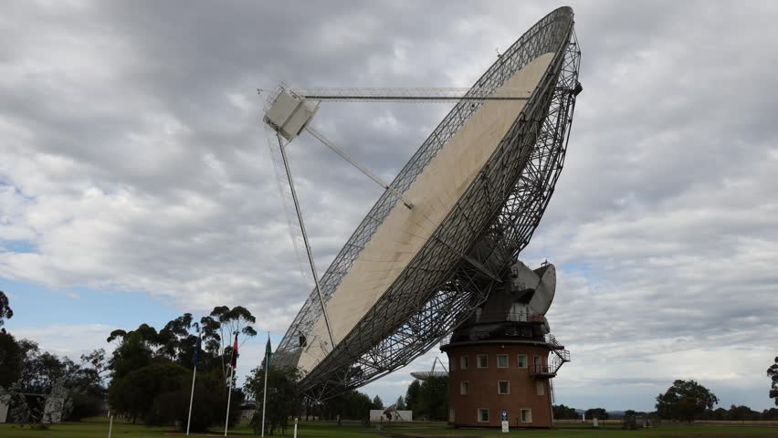 Large parabolic dish, radio telescope, technology, outdoor, daytime.