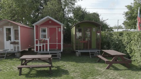 Aerial Drone Flight Past Wooden Cabins in Forest Camp