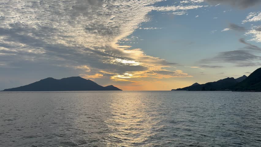 Serene seascape at sunset with silhouetted mountains