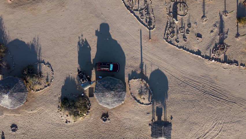 Aerial views capture sunrise over Bahia De Los Angeles in Baja California. The area features camping, beach, and simple structures.