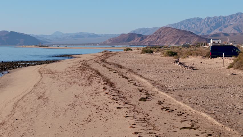 Watch the sunrise over Bahia De Los Angeles showcasing sandy beaches and camping areas in Baja California Mexico during early morning hours.
