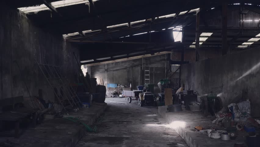 Lonely Farm barn interior displays cluttered tools and weathered concrete walls inside an abandoned rural storage building bathed in moody natural light through the damaged roof