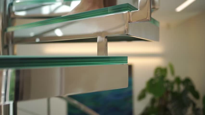 Elegant modern staircase with chrome railing and vibrant green glass treads