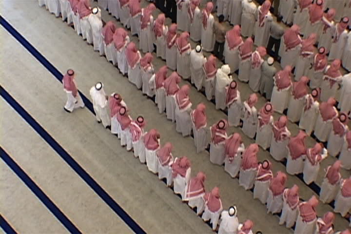RIYADH, SAUDI ARABIA - OCTOBER 01, 2002: Overhead view of university mosque. Hundreds of men dressed in white, with red and white checked keffiyeh, standing and bowing in unison.
