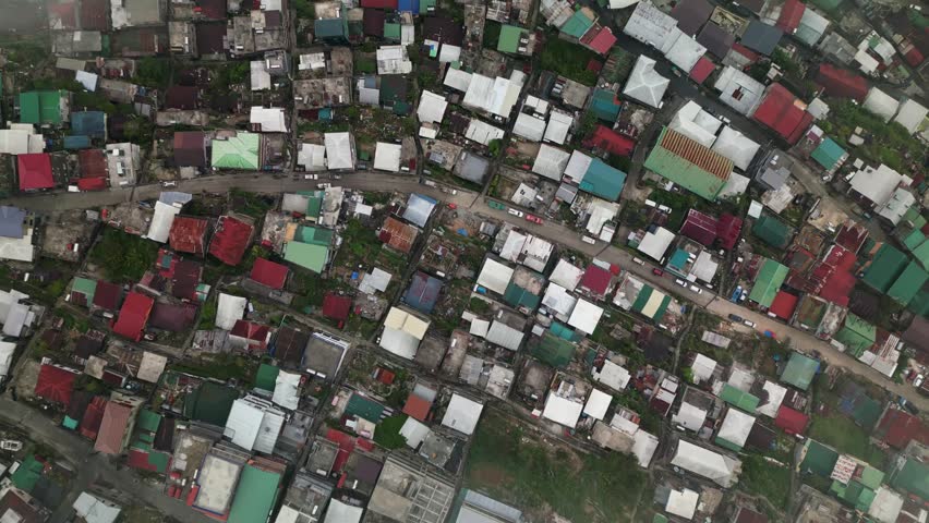 Panoramic aerial top-down shot of tightly packed hillside homes with colorful rooftops in Quirino Hill, Baguio City, Philippines.