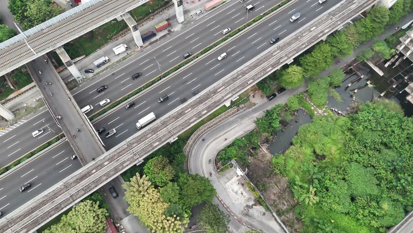 Aerial view of a curved highway ramp passing through a green landscape area.