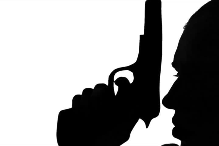 Young adult woman raises gun next to head profile.

