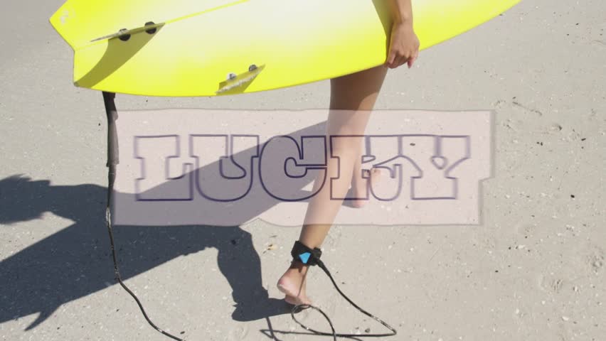 Woman carrying yellow surfboard walking to water to surf, leash trailing, LUCKY covering midsection. Female, beach, sand, board, ocean, shadow, sunshine