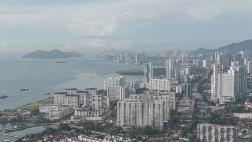 Historic urban preservation and tourism concept: Aerial view of the George Town UNESCO World Heritage Zone in Penang, Malaysia, showcasing traditional red-tile rooftops and heritage shophouses during a bright, quiet morning.