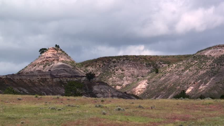Nebraska, USA badlands landscape showing eroded hills with native prairie grasses, static shot