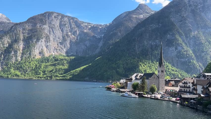 Stunning alpine view of a calm lake and snow-capped mountains in Austria.